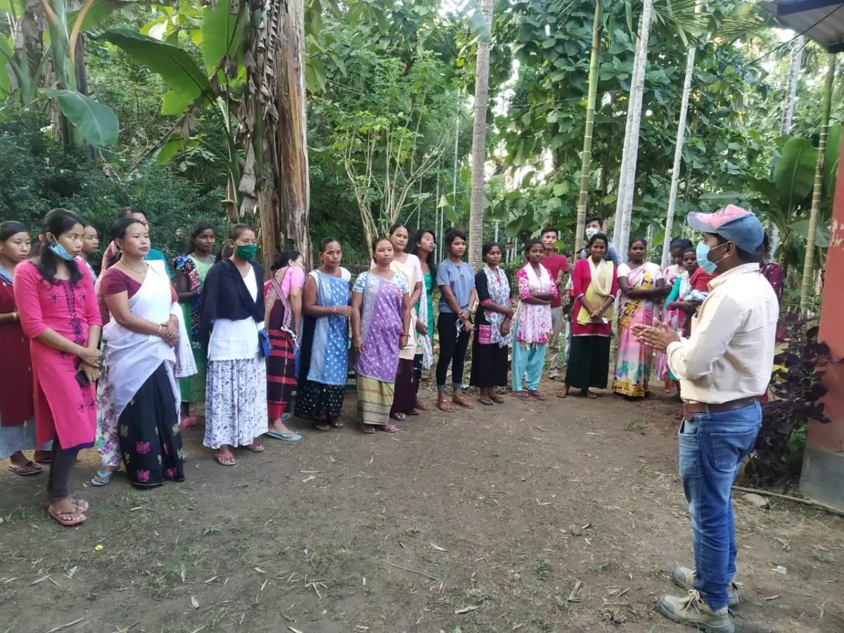 Women from a village community gathered outdoors for an awareness session