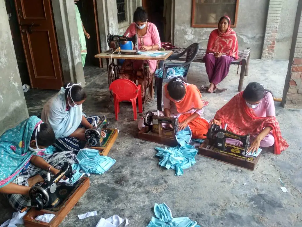 Women working at sewing machines during a tailoring programme